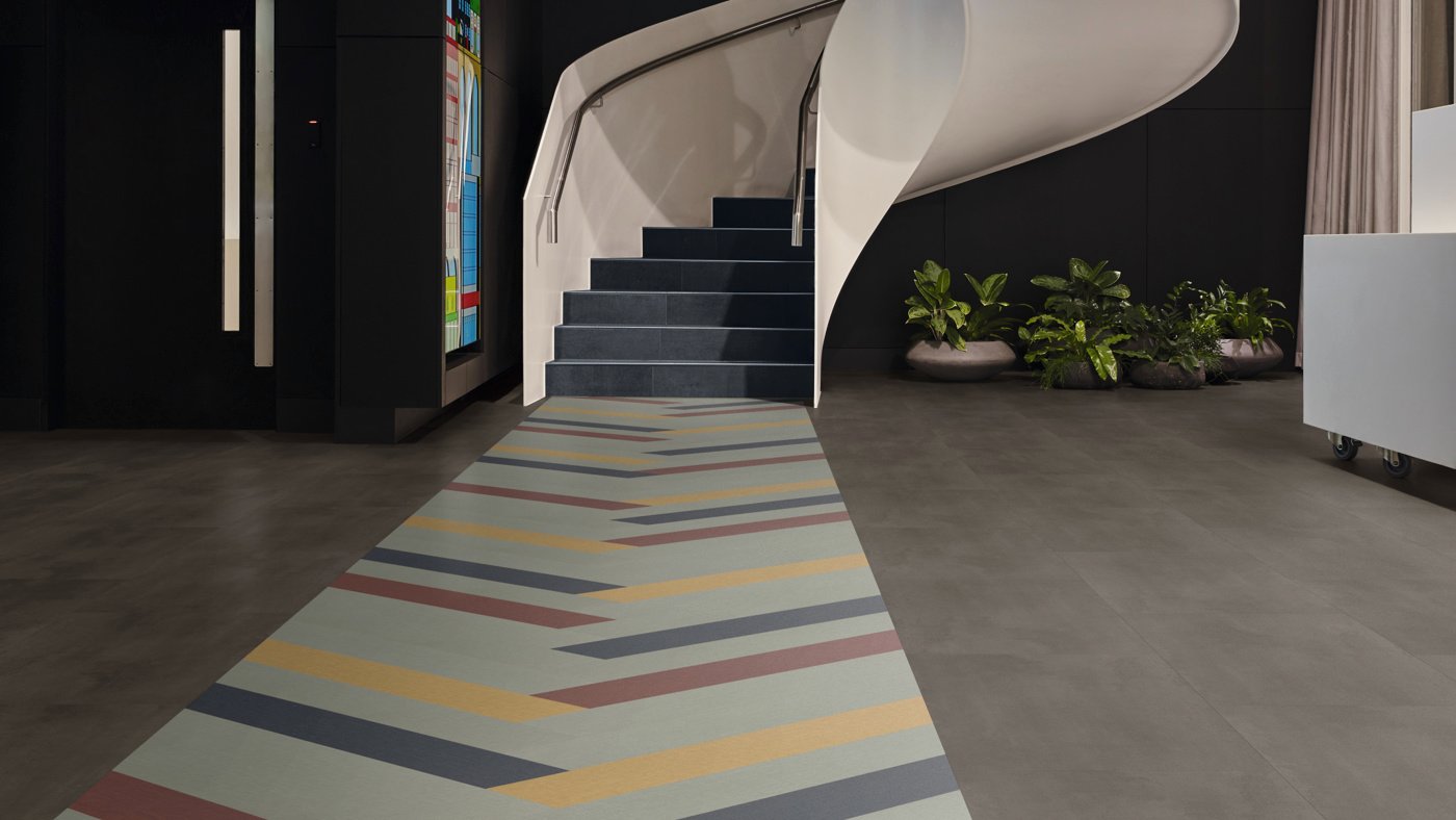 Opus abstract lvt floors create a bold wayfinding path, featuring Burnt Sienna SP719, Indigo SP710, Chalk Grey SP724, Yellow Ochre SP726 and Umbra SP732