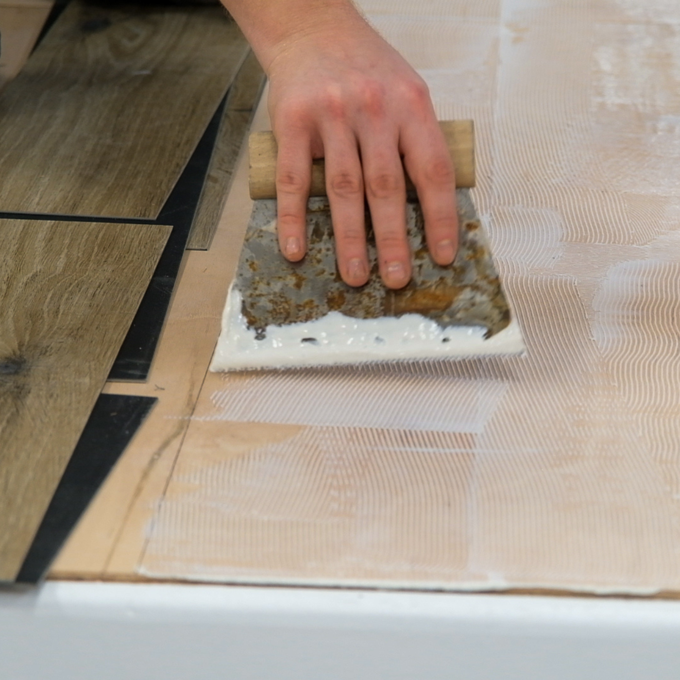 A trainer at a Karndean Commercial fitting course showing how to apply adhesive
