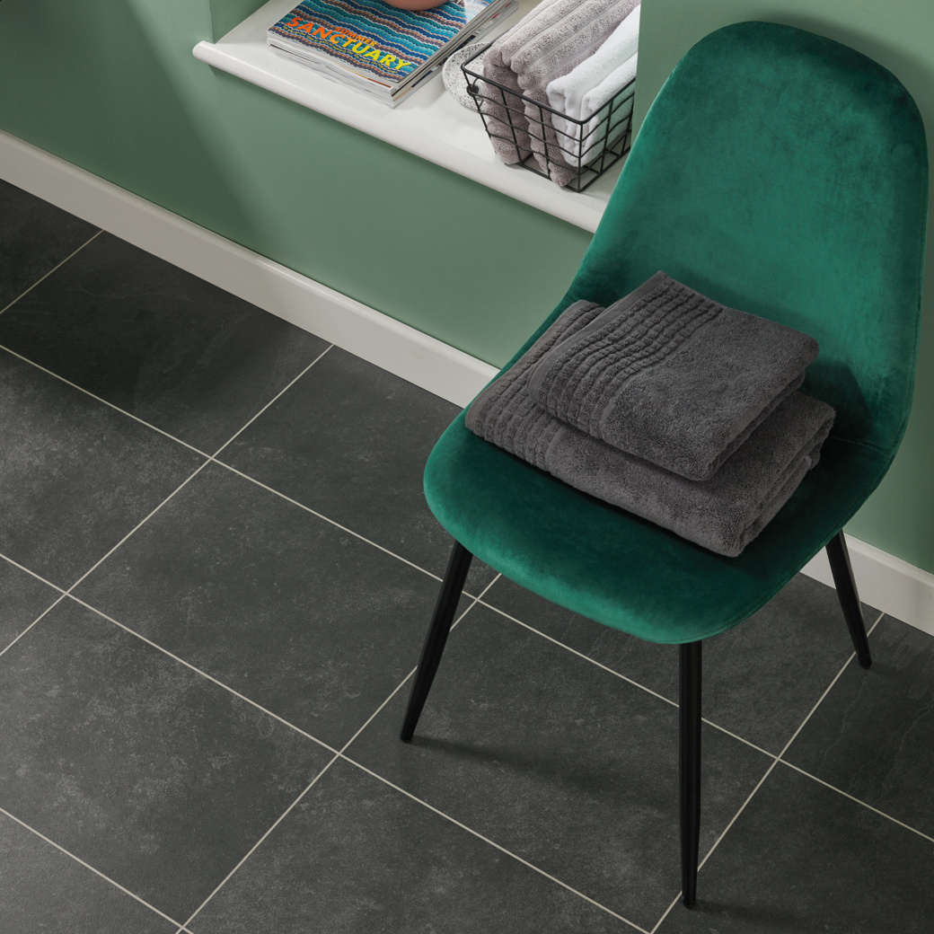 Knight Tile Black Riven Slate black LVT flooring with a chair