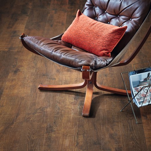 Antique French Oak Dark Brown LVT Flooring near a chair in an open space